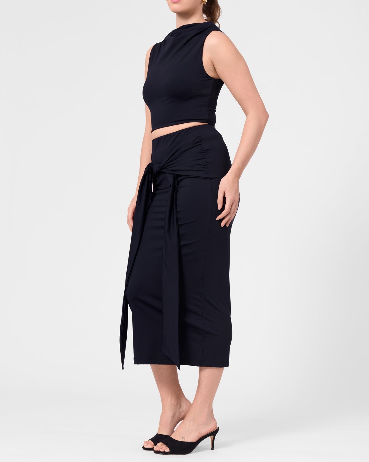 Model wearing the ROEM Grace Swim Top in Black, styled with the Itaso Skirt, side view