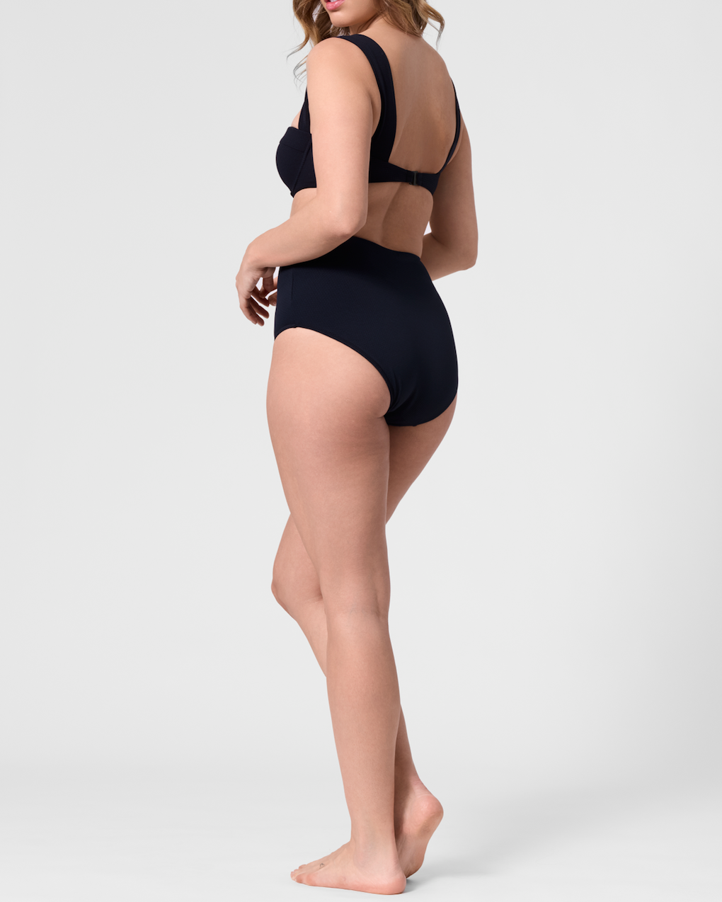Model wearing the ROEM Lana Texture Bottom in Black, side view