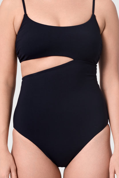 Model wearing the ROEM Nerissa One-Piece in Black, detail view highlighting the sculpted waist cutout